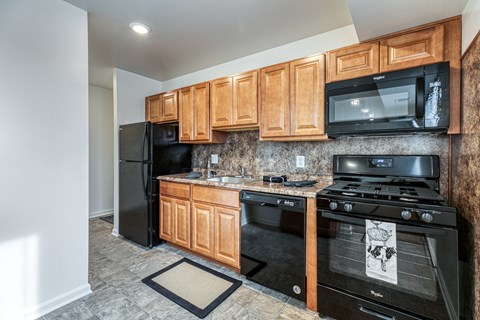 A kitchen with black appliances and wooden cabinets.