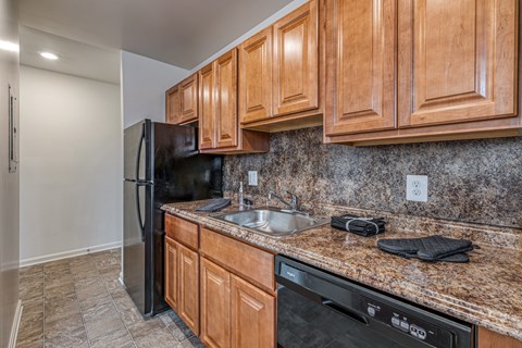 A kitchen with wooden cabinets and granite countertops.
