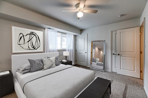 A bedroom with a large bed and a ceiling fan.