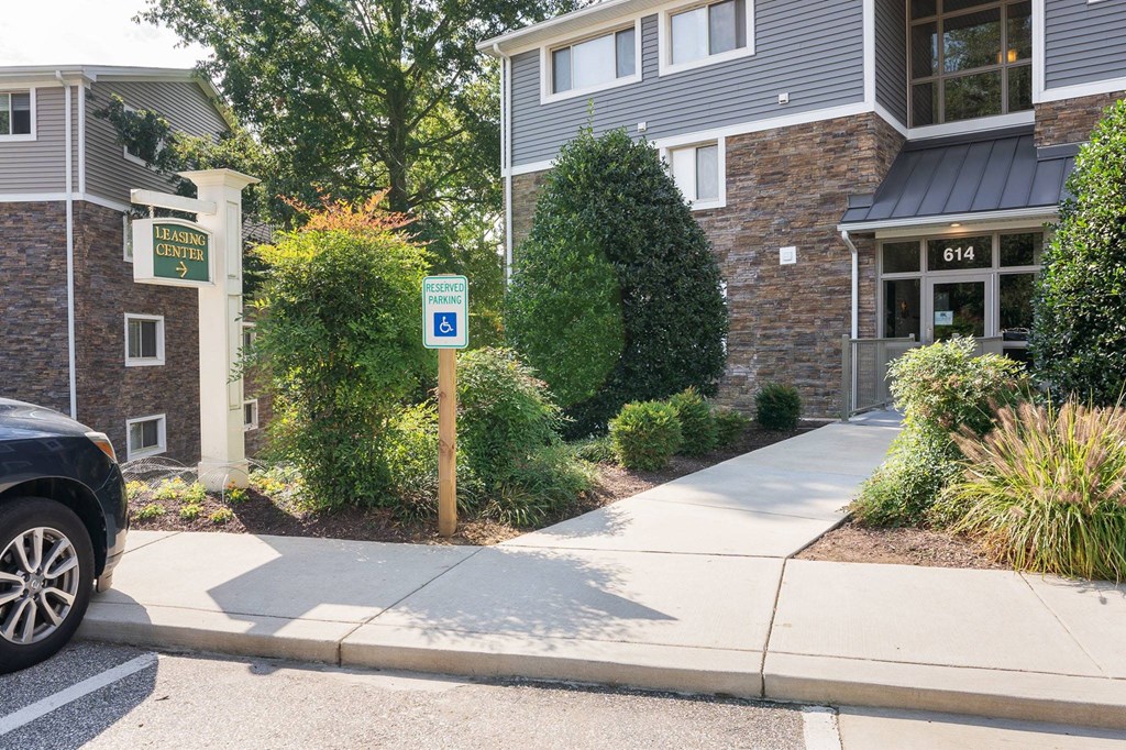 A parking sign is on a pole in front of a building.