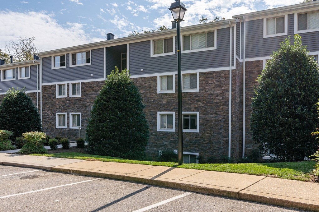 A street view of a residential area with apartment buildings and a sidewalk.