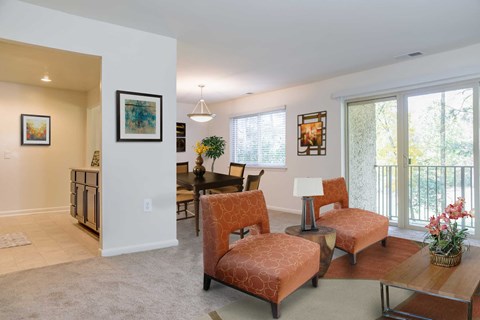 a living room and dining room with chairs and a table