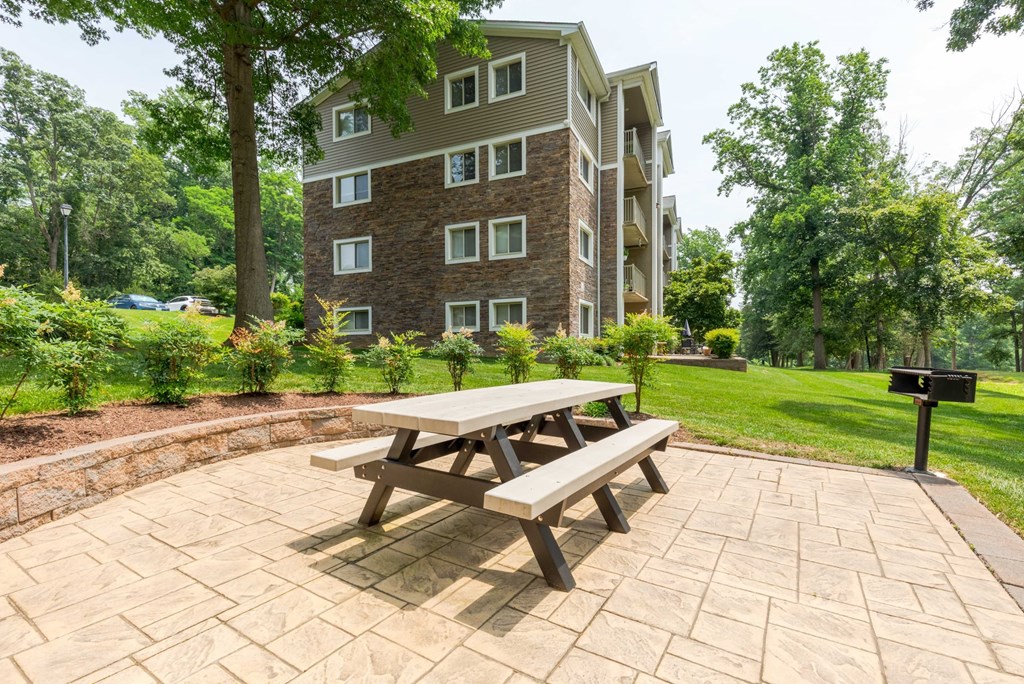 two green chairs and a picnic table in a park