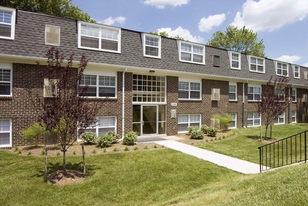 A brick building with a black fence in front.
