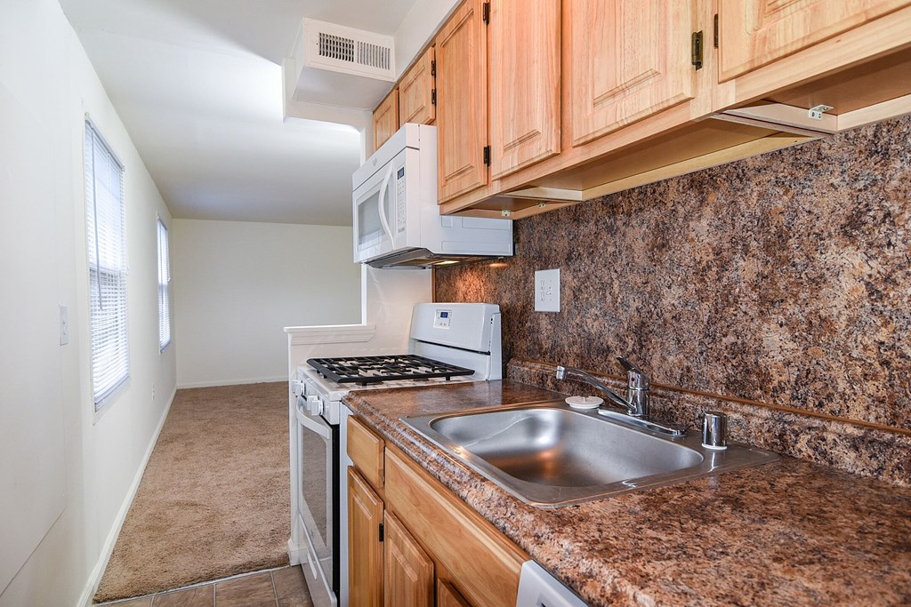 a sidewalk in front of a brick apartment building