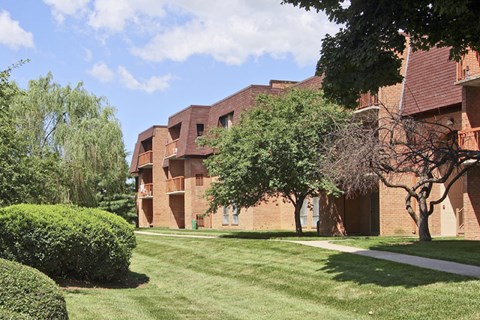 A red brick building with a green lawn in front.