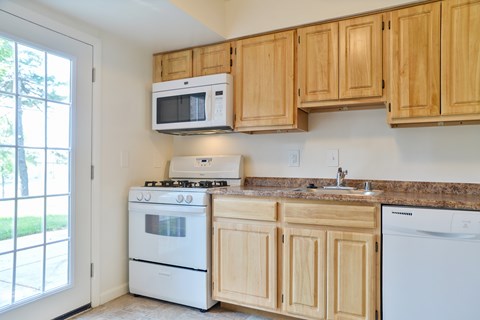 A kitchen with wooden cabinets and white appliances.
