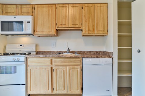 A kitchen with wooden cabinets and a granite countertop.