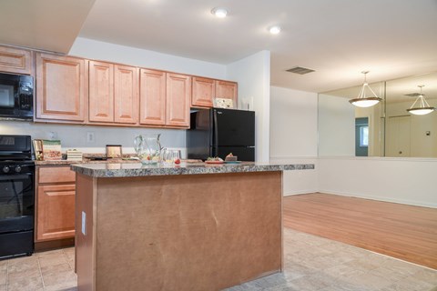 A kitchen with a brown counter and black appliances.