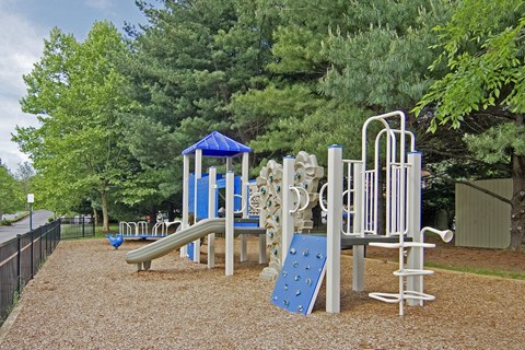 A playground with a blue slide and a white and blue structure.