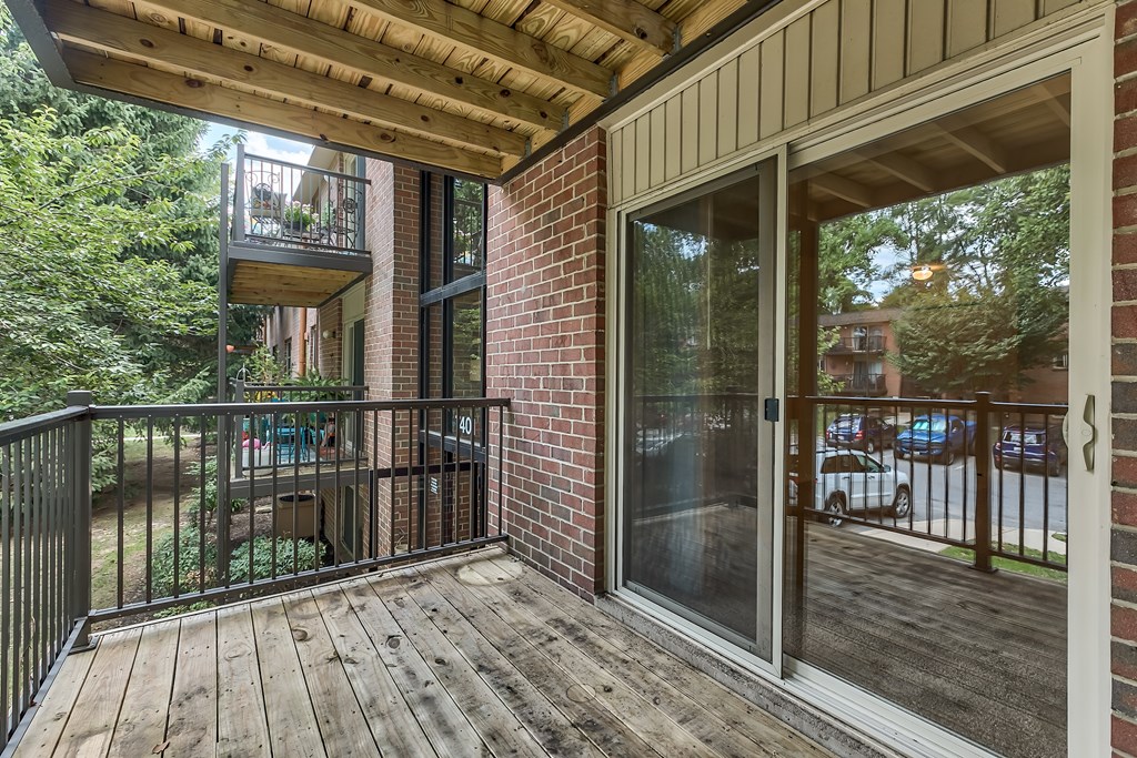 A balcony with a black railing and a glass door.