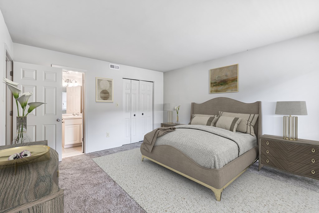 A bedroom with a large bed, a dresser, and a nightstand.