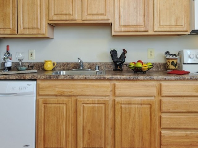 A kitchen with wooden cabinets and a white dishwasher.