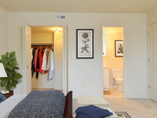 A bedroom with a bed, a wardrobe, and a toilet in the bathroom.