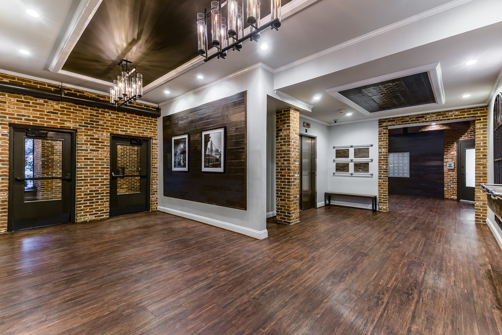 A room with wooden floors and brick walls.