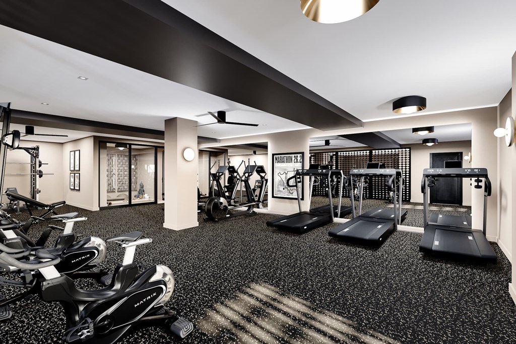A gym with a variety of equipment including treadmills, stationary bikes, and weight machines.
