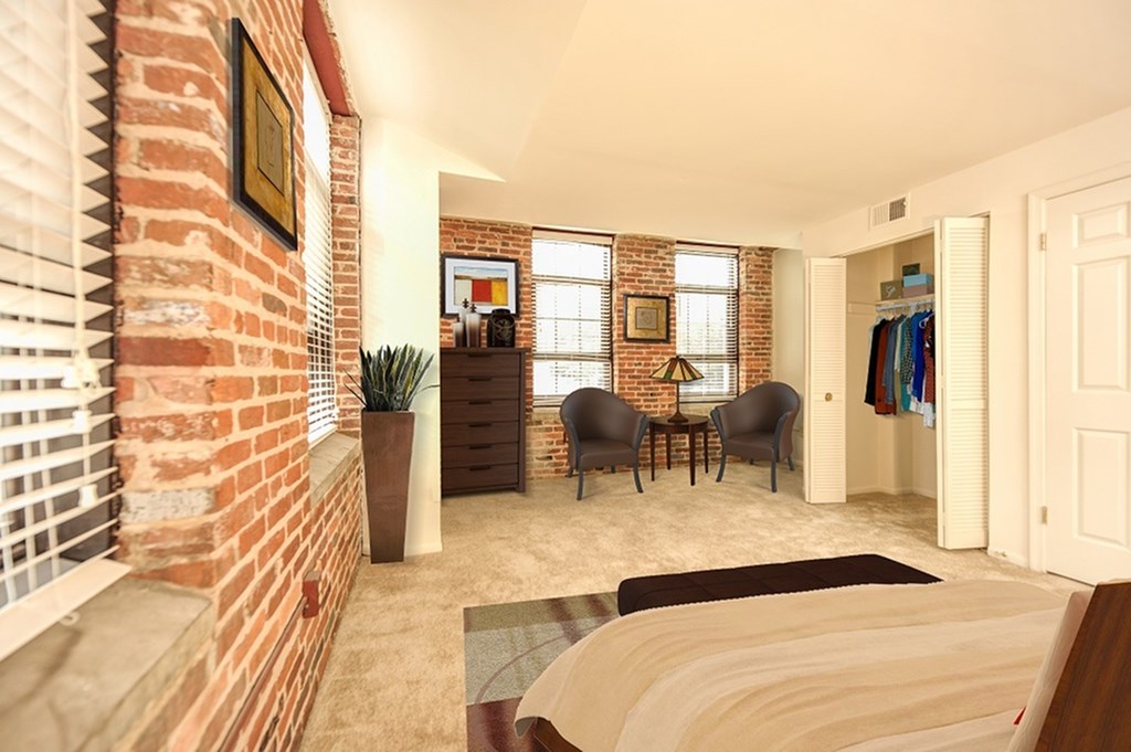 A living room with a brick wall and a couch.