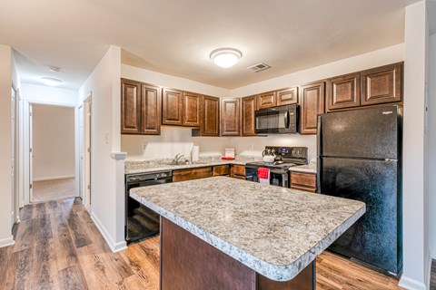 A kitchen with wooden cabinets and a granite countertop.