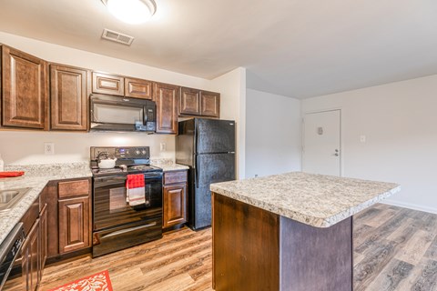 A kitchen with dark wood cabinets and appliances.