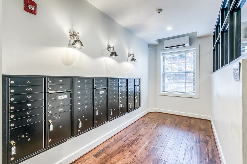 A long row of mailboxes are lined up on a wall.