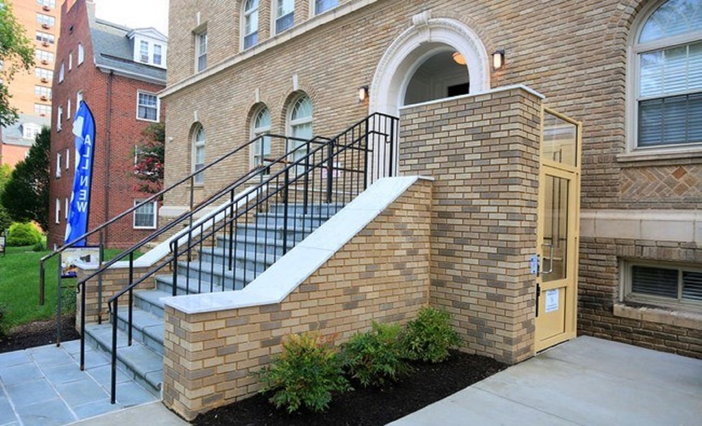A brick building with a staircase leading to a door.