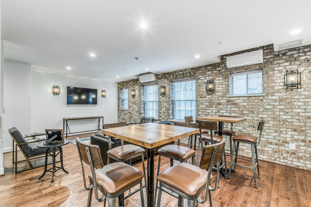 A dining room with a brick wall and a wooden table.