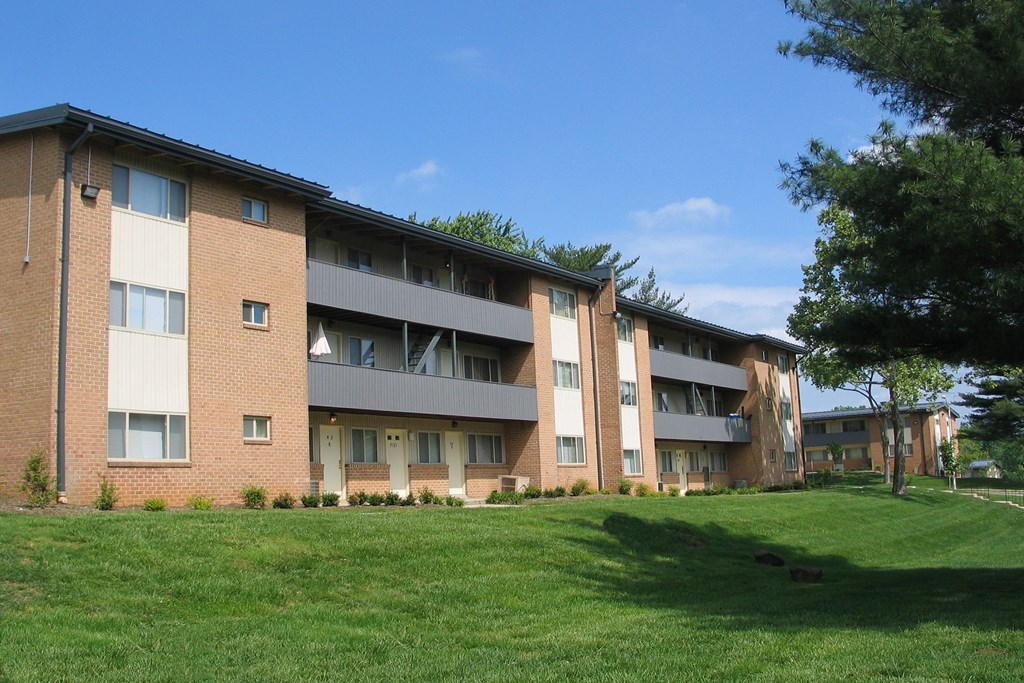 A large apartment complex with a green lawn in front.
