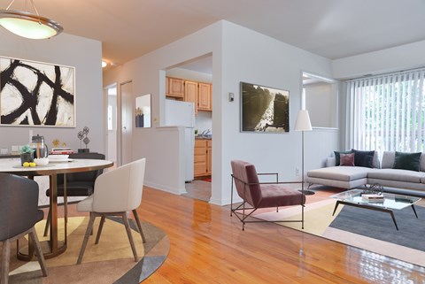A modern living room with a dining table and chairs.