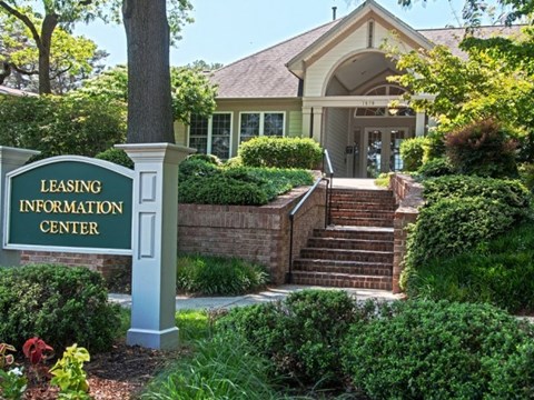 A leasing information center sign is in front of a building.