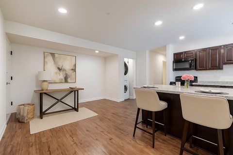 A living room with a white couch, a chair, a coffee table, and a television.