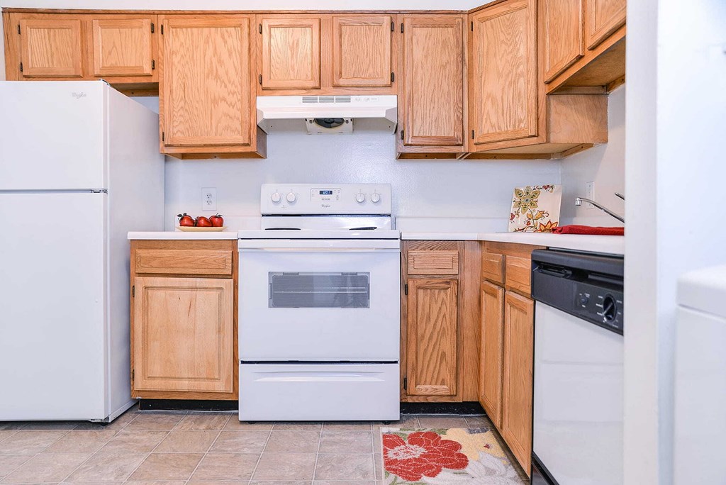 a kitchen with white appliances and wooden cabinets