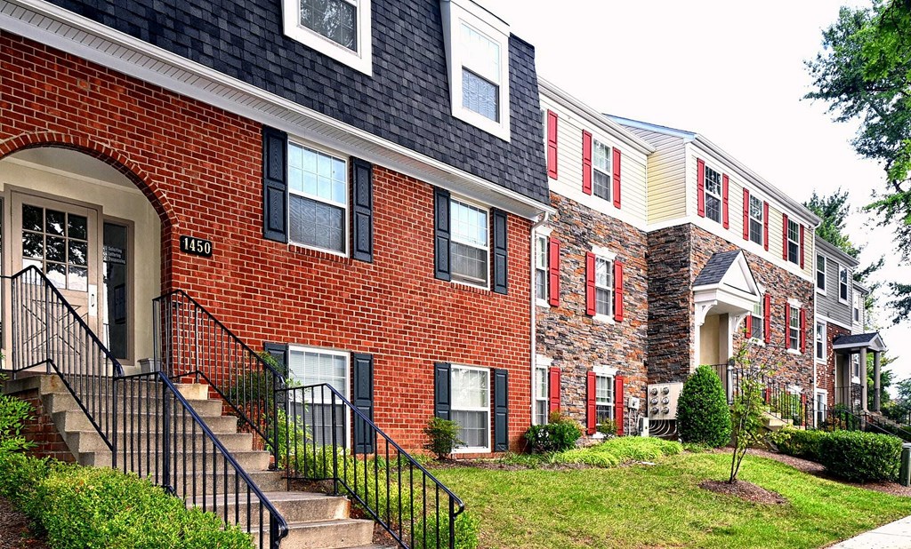 a brick house with red and white windows
