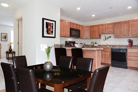 A dining room with a table and chairs.