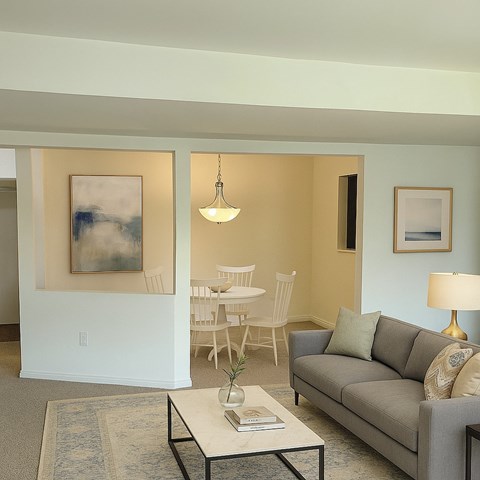 A spacious empty room with carpeted floor and white walls.