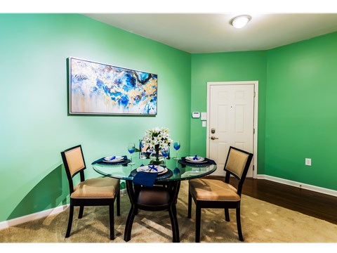 A dining room with a glass table and chairs.
