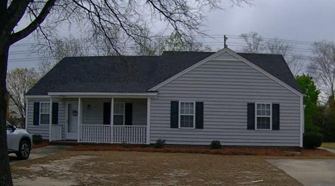 a white house with black shutters and a front porch