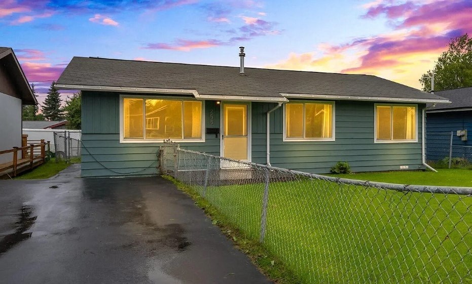 a blue house with a fence in front of it