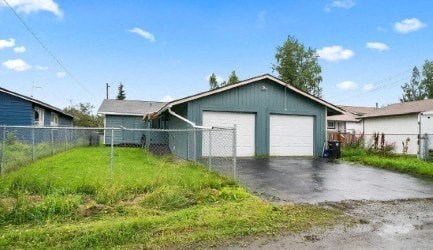 a blue house with a fence and a garage