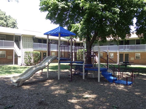 a playground in a yard in front of a building
