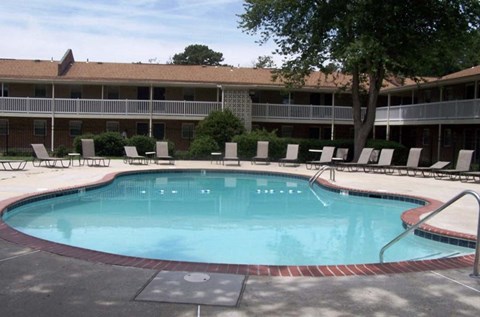 a large swimming pool in front of a hotel building