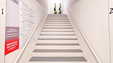 A staircase with a sign on the wall on the left.