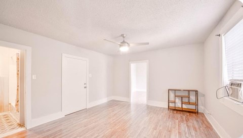 A room with a wooden floor and a ceiling fan.