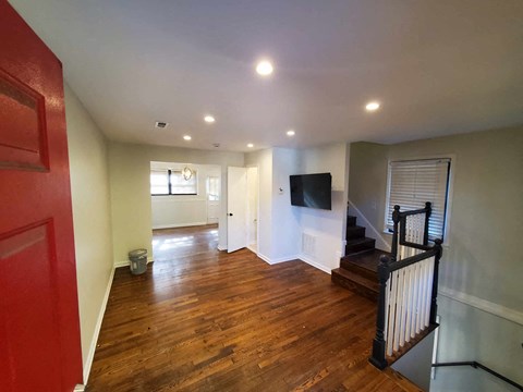 a living room with a staircase and a tv