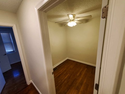 a bedroom with a ceiling fan and wood floors