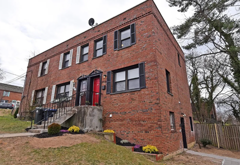an old brick building with red doors and black windows