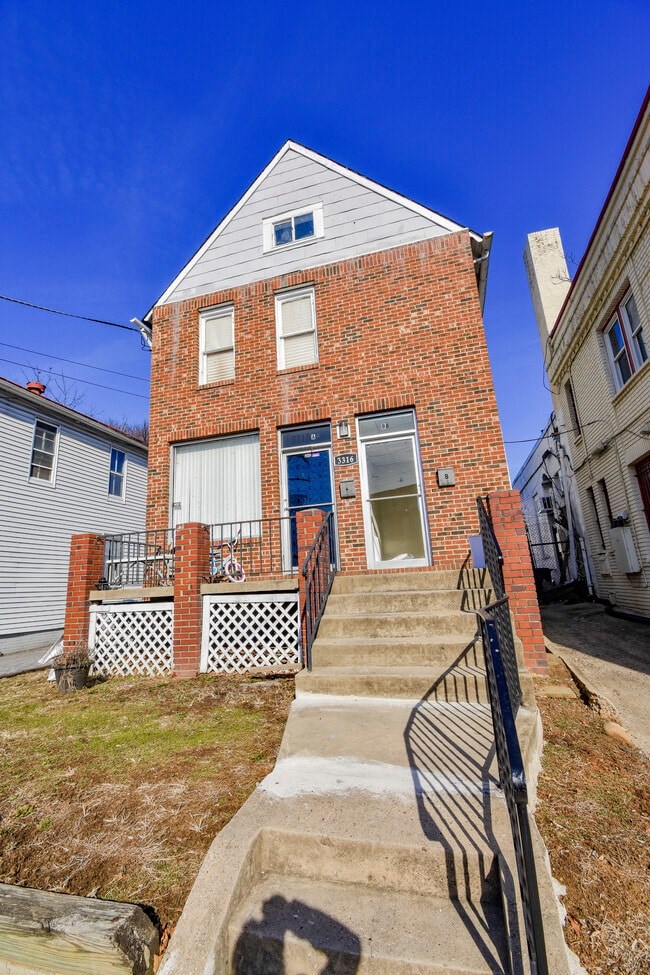 A house with a red brick facade and a white roof.