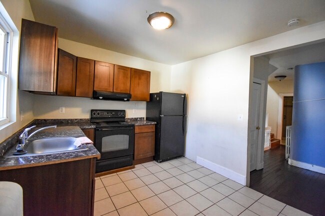 A kitchen with black appliances and wooden cabinets.