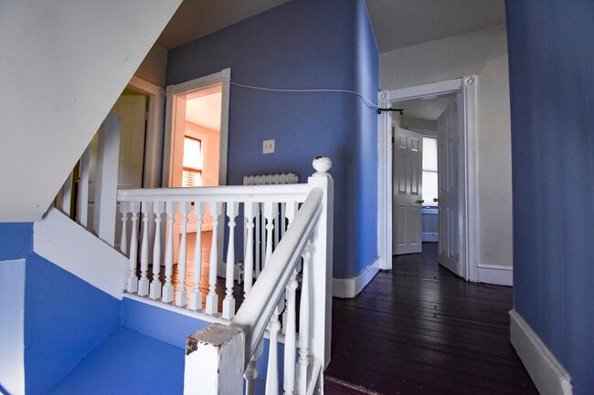 A staircase with a white railing and blue walls.