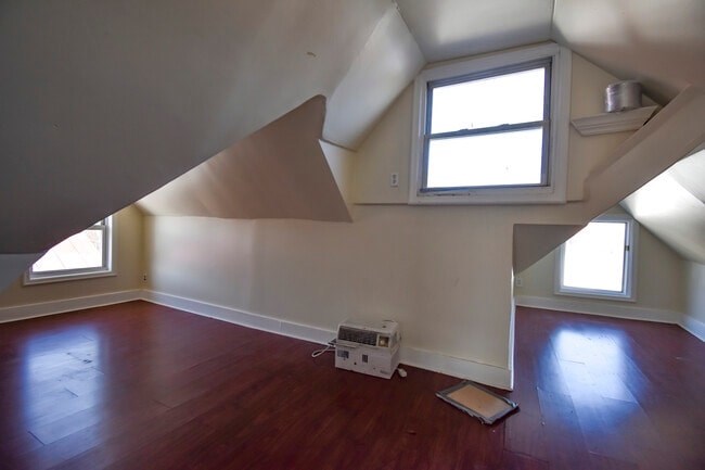 A room with a window and a wooden floor.