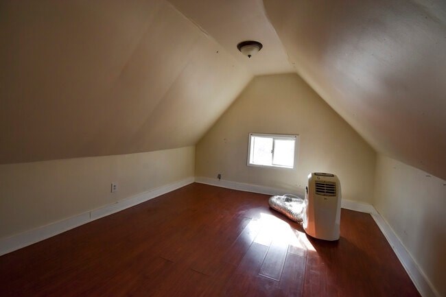A room with a window and a fan on the floor.